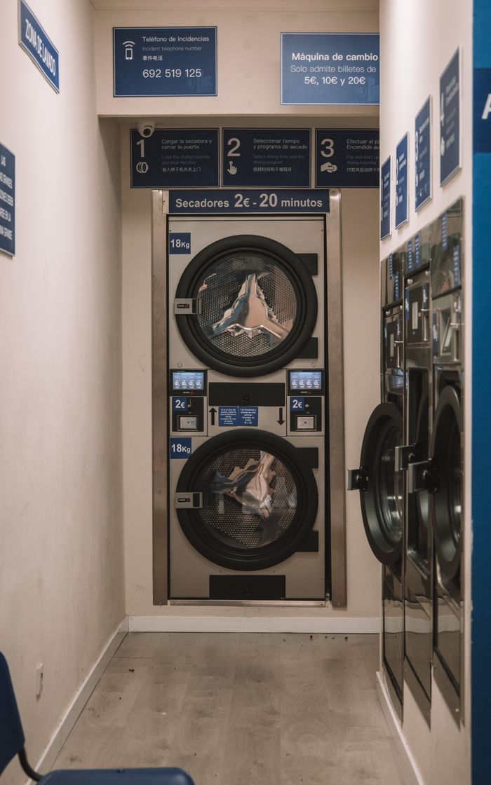 Interior view of a laundromat in Valencia, Spain with industrial washing machines.